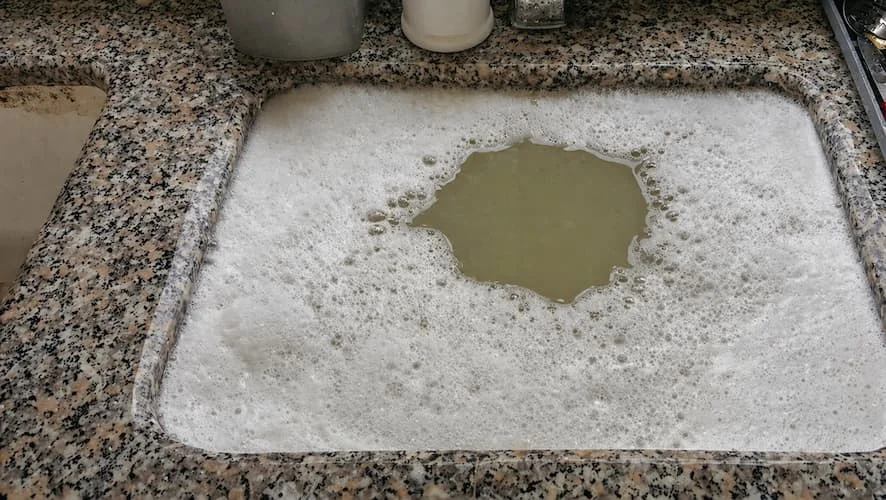 Blocked kitchen sink with standing dirty water and foam, clear sign of drainage problem in Great Yarmouth property